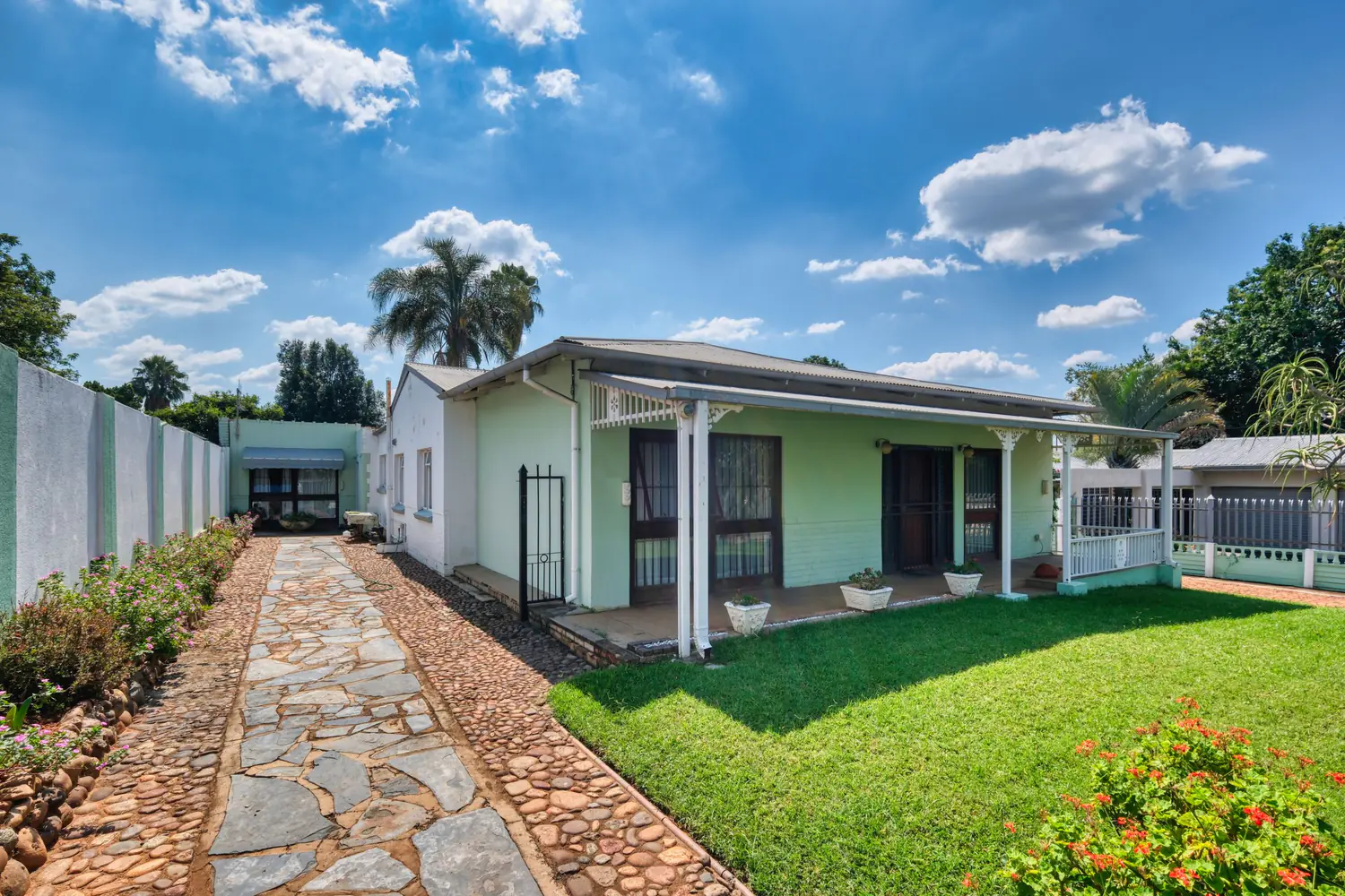 A welcoming residential property with a green lawn and landscaped garden path