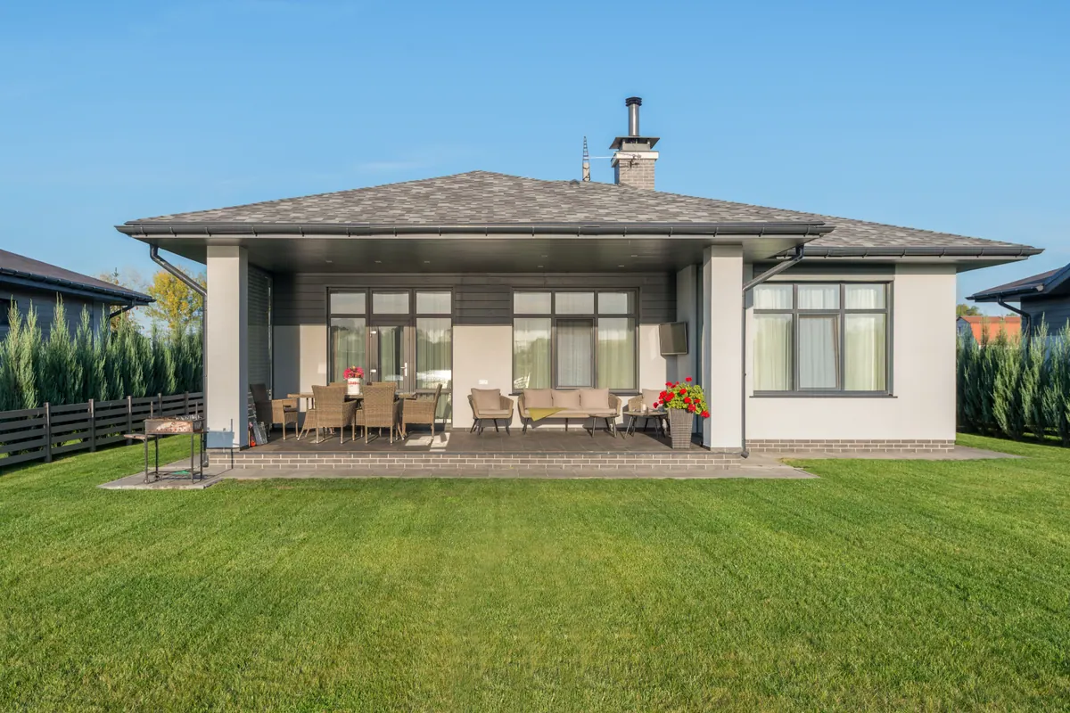 A clean backyard lawn maintained around a modern home
